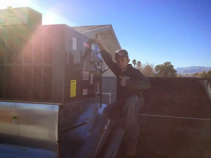 HVAC technician performing Heat Pump Repair on a rooftop unit in CaÃ±on City
